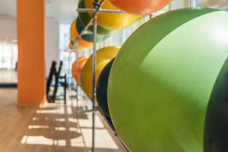 Rack with exercise balls of various colors in modern fitness gymの写真素材