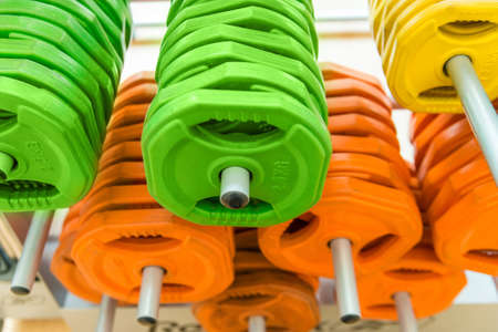 Closeup image of color dumbbells in modern gymの写真素材
