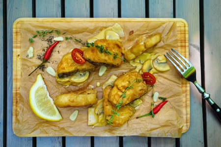 Fried fish in batter with herbs and lemonの写真素材
