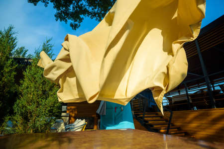 Putting tablecloth on table at outdoor summer cafeの写真素材