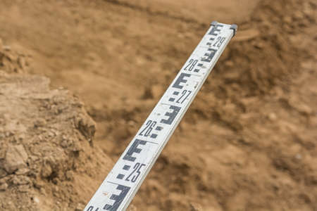 A level staff, also called levelling rod, is a graduated wooden or aluminum rod, the use of which permits the determination of differences in elevation.の写真素材