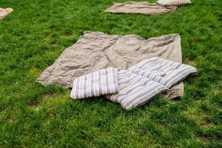 Picnic blanket with pillow on the beautiful grass fieldの写真素材