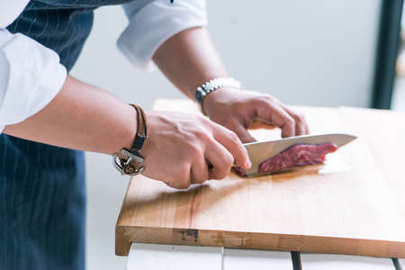 Closeup image hands and knife slicing hamの写真素材