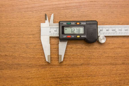 Close-up photography of engineering caliper on wooden backgroundの写真素材