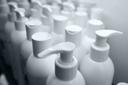 Many white shampoo bottles on store shelfの写真素材