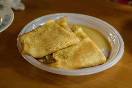 Delicious pancakes with honey on plate on table close-up