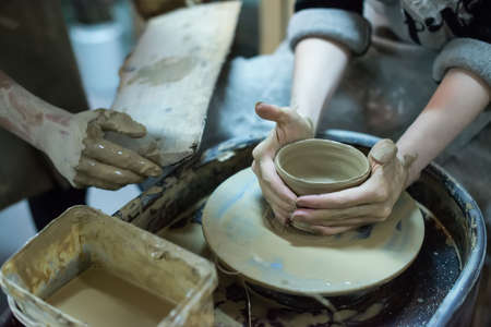 Hands working on pottery wheelの写真素材