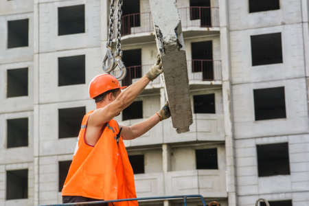 Worker setting up concrete panels during building constructionの写真素材