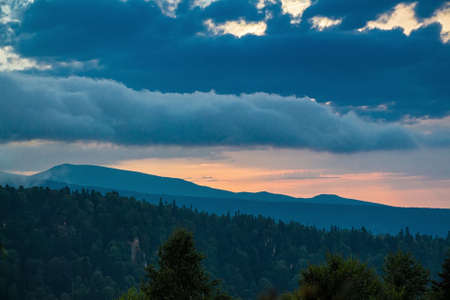 Scenic mountain landscape with sunset and dramatic skyの写真素材