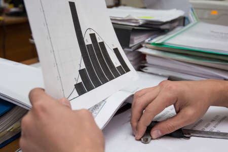 Business analysis - table, sheet, graphs, business report, diagrams and analyst's hands, top viewの写真素材