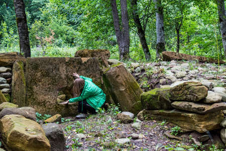 Tourist explores dolmen in the forestの写真素材