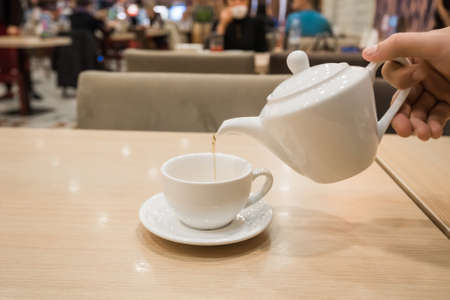 Teapot and cup of tea in cafeの写真素材