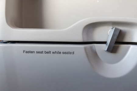 Fasten seat belt while seated sign on airplane and table in chair