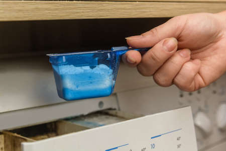 Young woman launching washing machineの写真素材