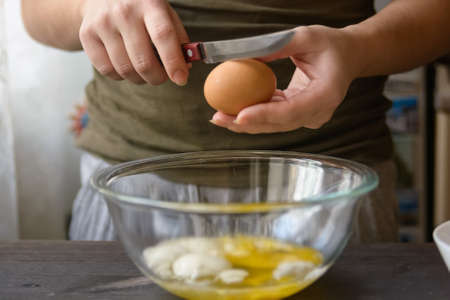 Woman hands breaking egg