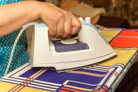 Close-up of female hand ironingの写真素材