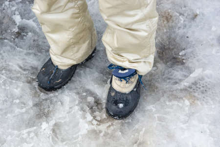 Hiking boots in the melting snowの写真素材