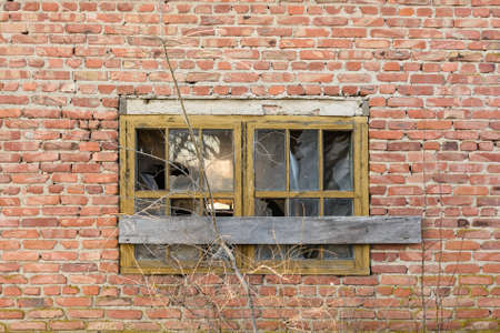 Old boarded-up window on brick wallの写真素材