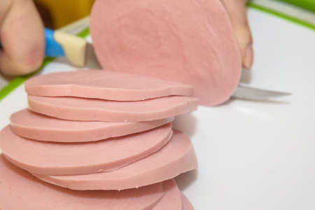 Bologna sausage thin sliced cut with knifeの写真素材