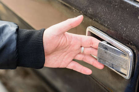 Close up of male hand opening old wooden doorの写真素材