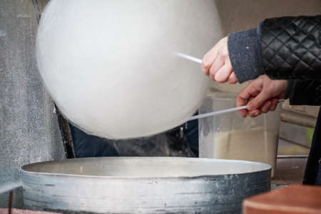 Making white cotton candy in cotton candy machineの写真素材
