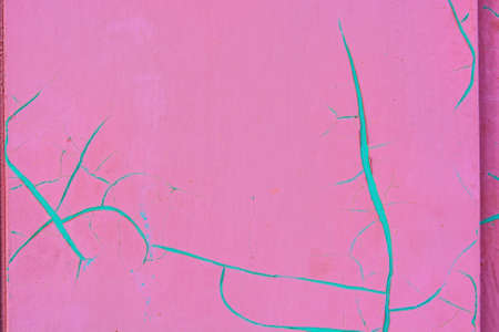 Bright pink cracked paint with cian color in cracksの写真素材