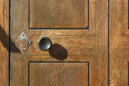 Round metal door handle on wooden door close upの写真素材