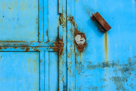Old rusty metal door painted blueの写真素材