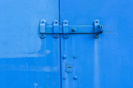 Old blue door hingeの写真素材