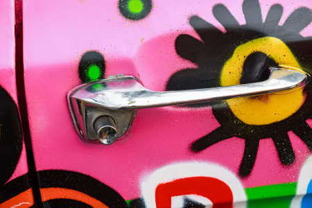 Close up doorhandle of pink colorful carの写真素材
