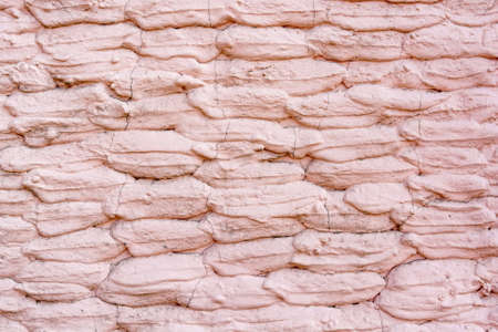 Close up stone wall covered with old pink plasterの写真素材