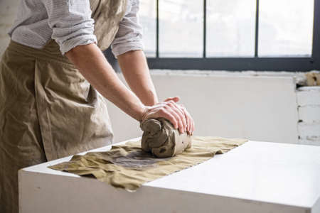 Man crumples piece of white clay for sculptingの写真素材