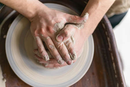 Hands working on pottery wheelの写真素材