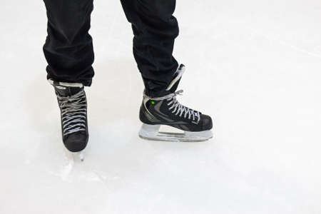 Close up male feet in skates on iceの写真素材