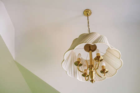 Modern white plastic chandelier hangs from ceilingの写真素材