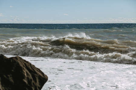 Seascape with powerful wave and rock on the seashoreの写真素材
