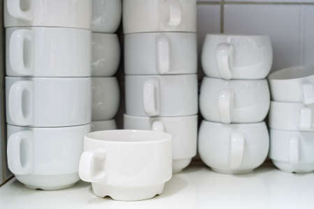 Stacked white clean cups in restaurantの写真素材