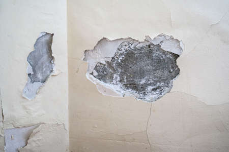 Damaged plaster on wall indoors close upの写真素材