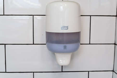 Liquid soap dispenser on wallの写真素材