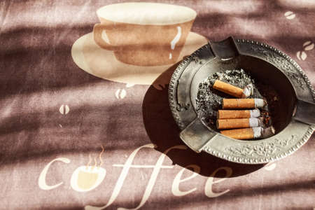 Cigarettes in black metal ash trayの写真素材