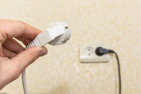 Male hand puts plug in the socket
