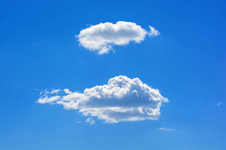 Two white clouds against blue skyの写真素材
