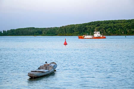River lanscape with small boat and bargeの写真素材