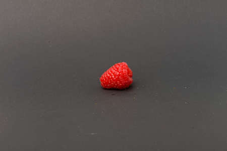 Single raspberry on grey backgroundの写真素材
