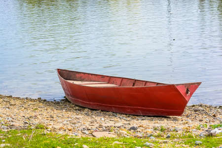 Red boat moored on the river in summerの写真素材
