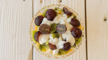 Bowl of healthy fresh fruit salad with creamの写真素材