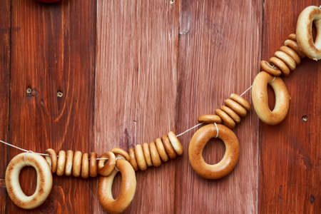 Bagels hang on rope on wooden backgroundの写真素材
