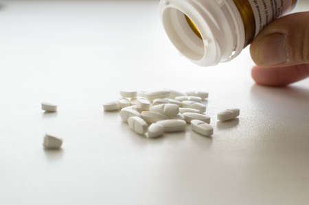 Close up putting whie pills on table