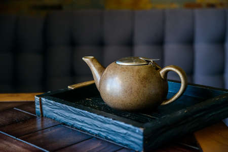 Vintage teapot on wooden board in restaurantの写真素材