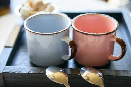 Tea set with two metal cups and spoons on trayの写真素材